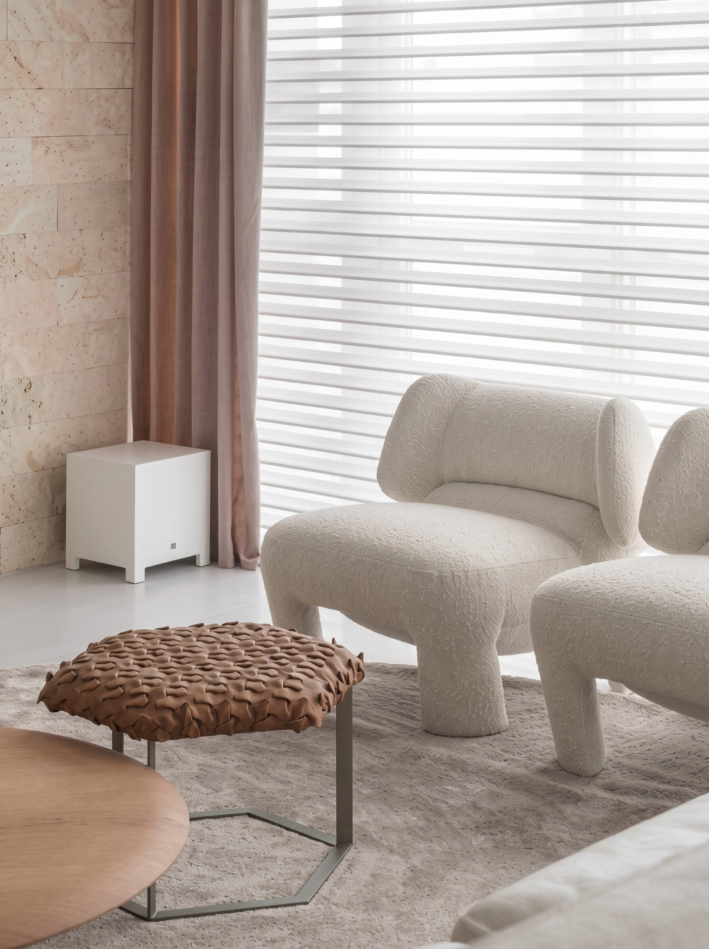 Ambiente com poltrona estofada, mesa de madeira e cortinas Hunter Douglas filtrando a luz natural
