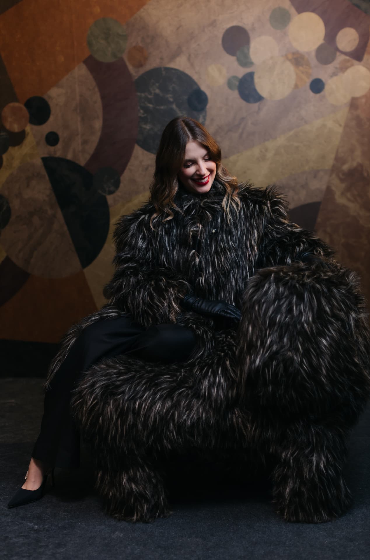Retrato de participante envolta em casaco de pelos na 2ª Mostra de Design, Arte e Moda