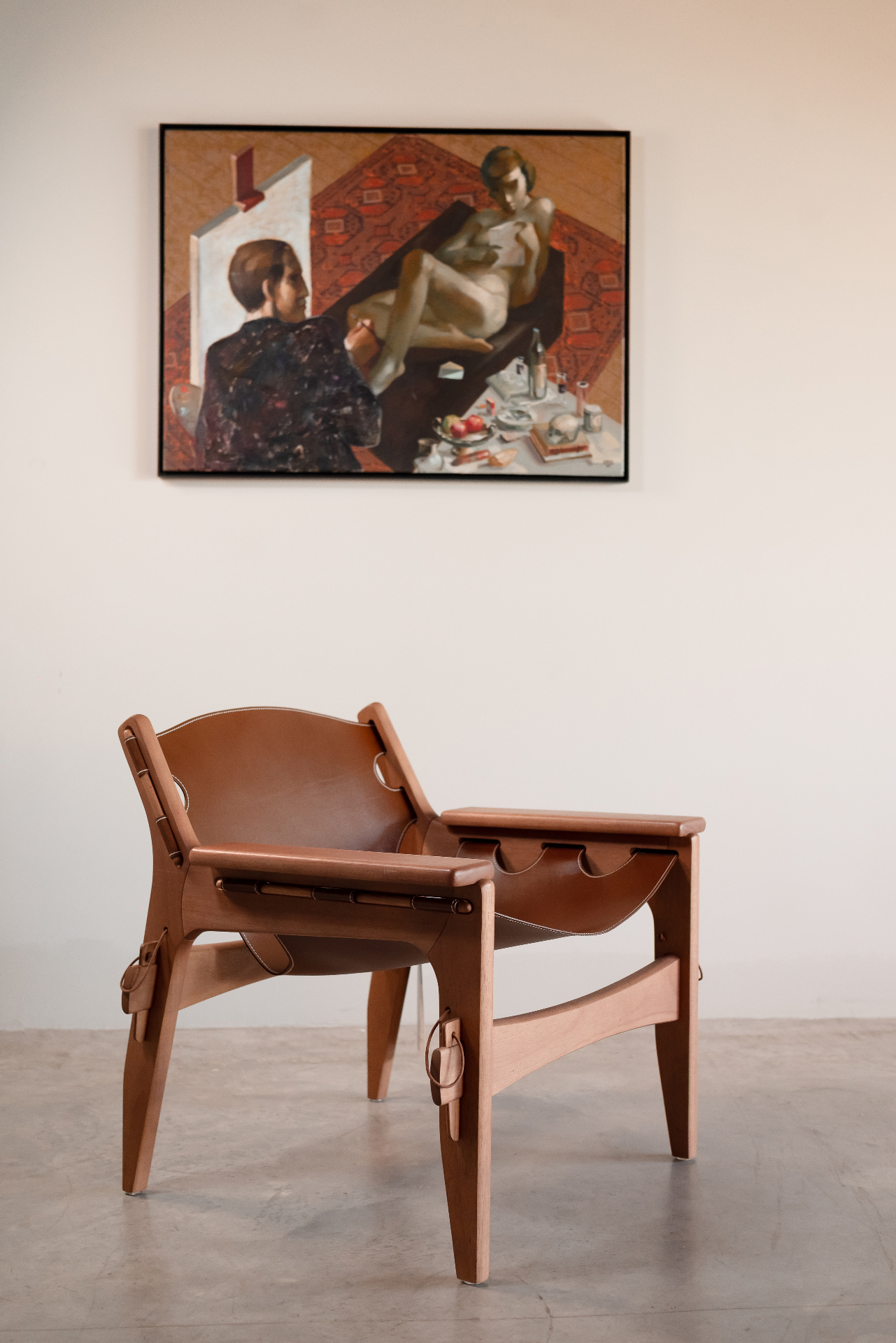 Carta ao modelo de Juarez Machado exposta em ambiente da Galeria Luize Home, acompanhada de poltrona de couro caramelo em madeira clara