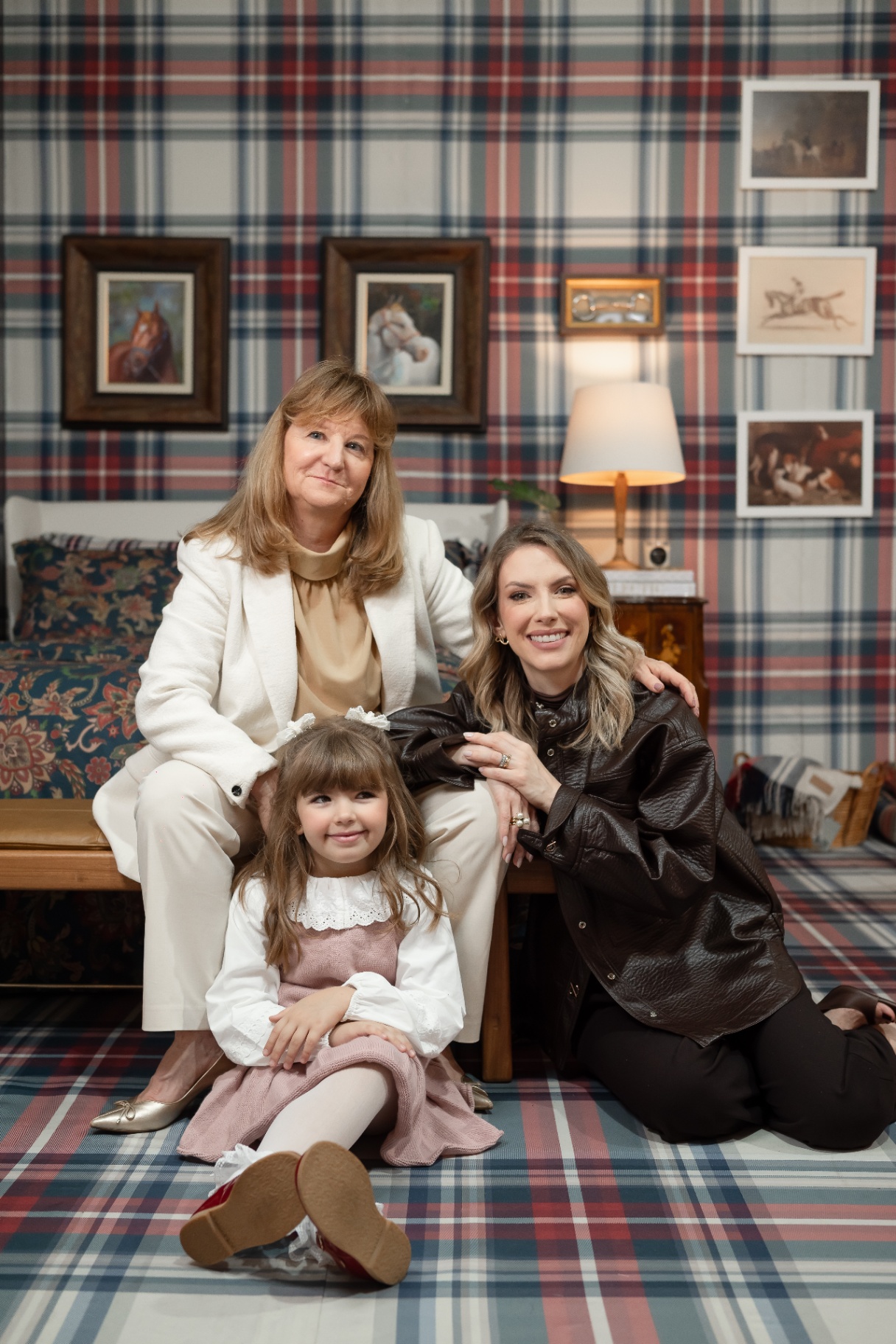 Retrato de três gerações no ambiente tartan, com tapete e papel de parede xadrez